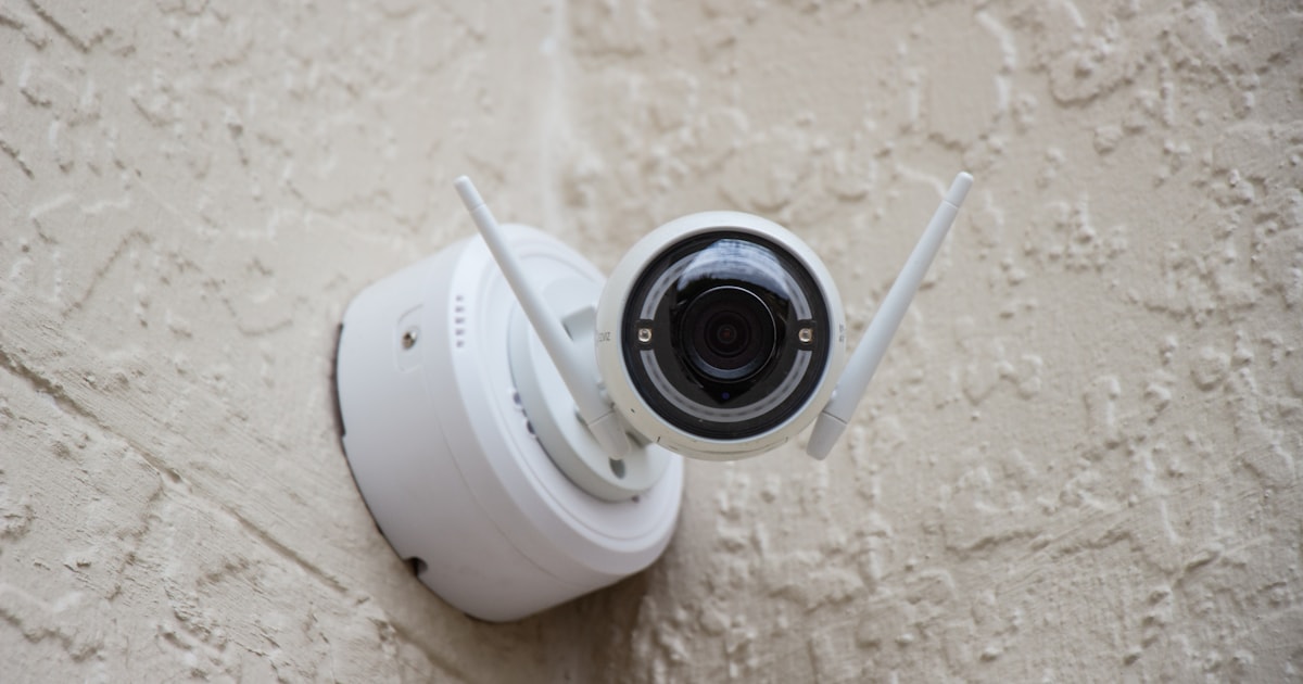 Videoüberwachung im Unternehmen DSGVO-konform — Kamera mit Hinweisschild am Eingang
